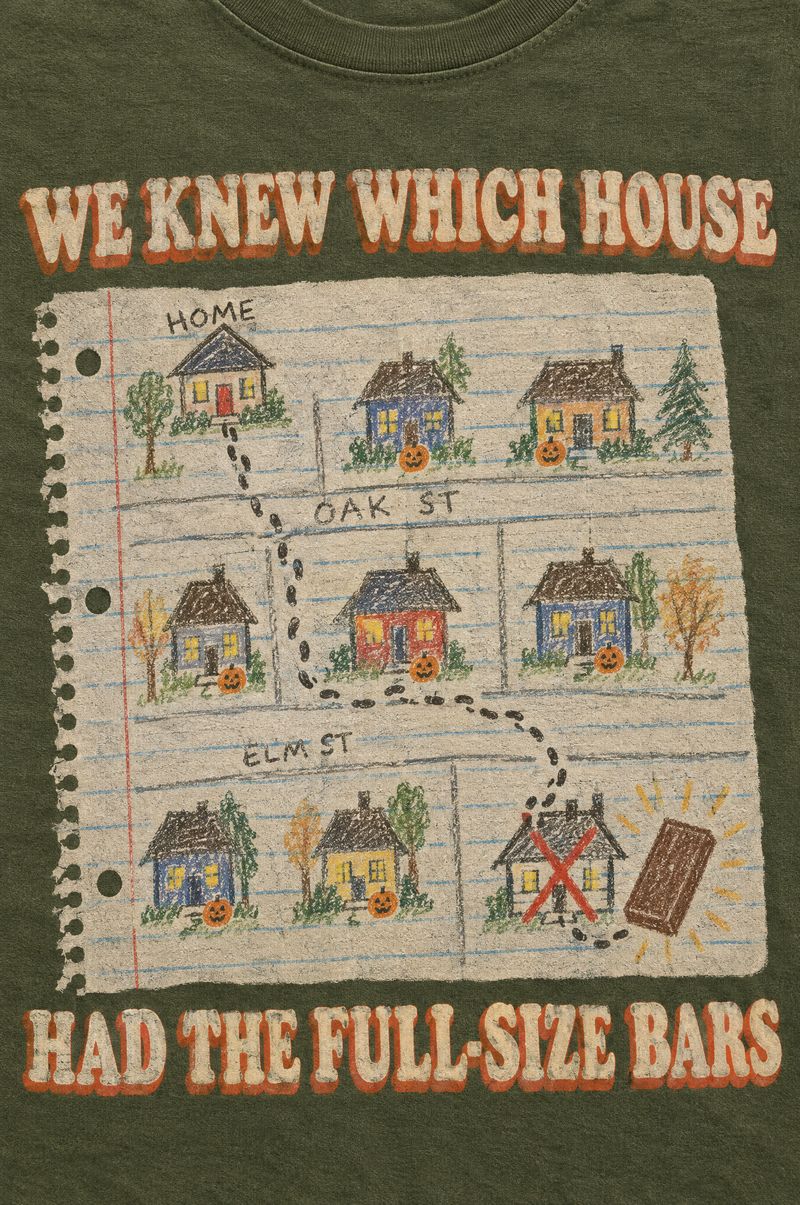 Moss green tee printed with a kid’s crayon map of the neighborhood on notebook paper with a red X on one house and a giant candy bar, words We Knew Which House Had the Full-Size Bars